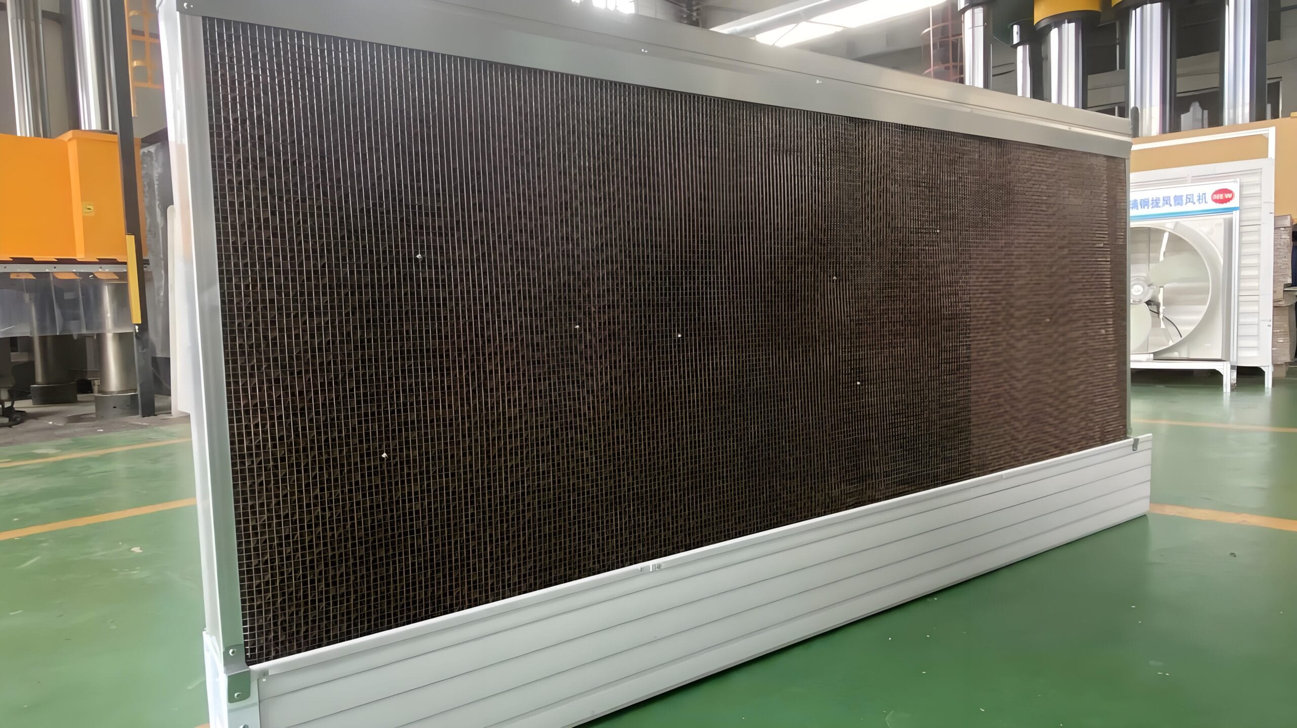 Close-up of evaporative cooling pad installation with water distribution system in poultry house